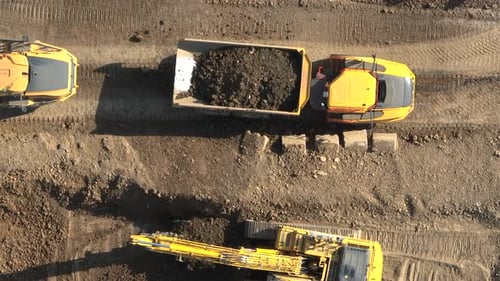 Excavator Loads Soil into Dump Truck Aerial View