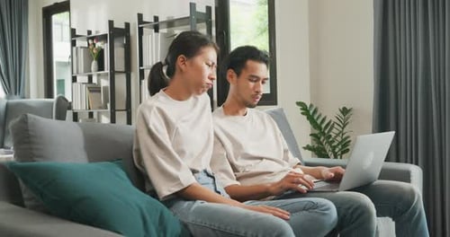 Couple Relaxing at Home Using Laptop