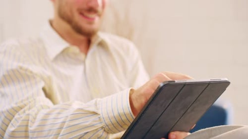 Close up of Caucasian businessman using digital tablet in living room.