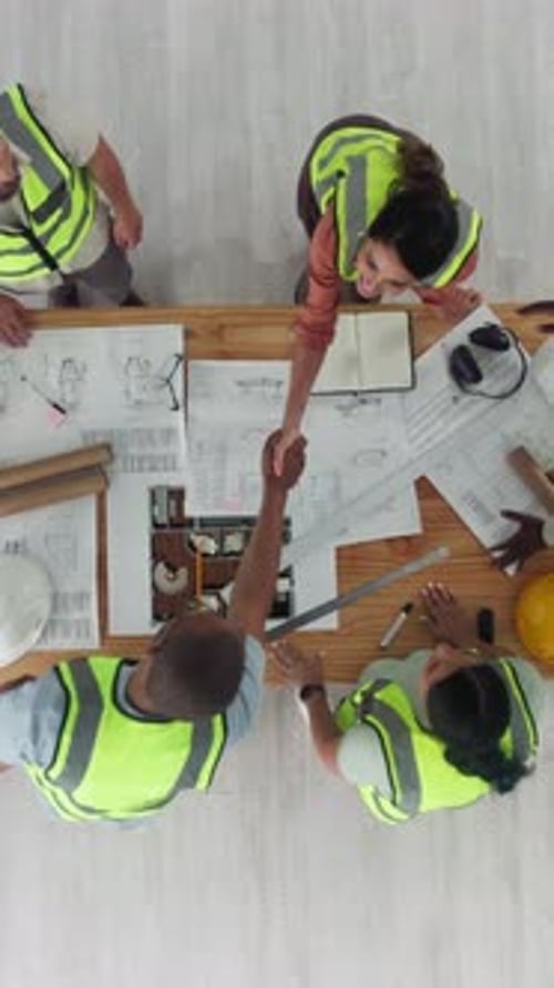 Architecture, handshake and above of people with blueprint for design, floorplan and building