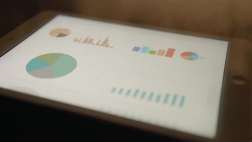 Tablet Displays Colorful Business Charts and Graphs