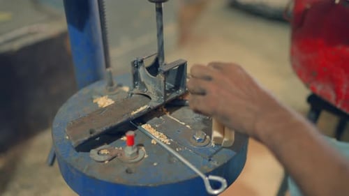 Close up shot of a man chipping of wood for making tent in Pakistan