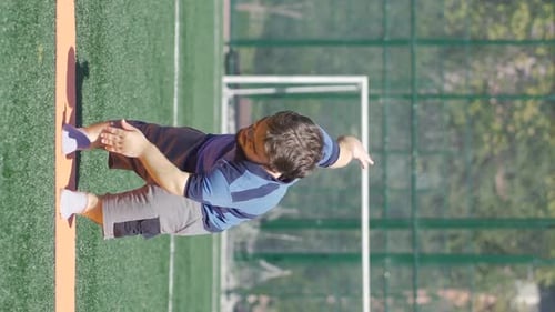 Man Warming Up on Green Sports Field