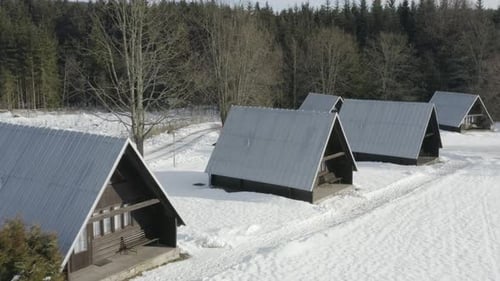 Aerial Shot Of Wood Ski Cabins At A Winter Ski Camp, Alpine Lodging In Beautiful Snow Covered Landsc