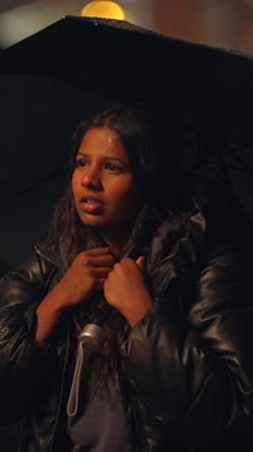 A Thoughtful and Contemplative Moment Beneath an Umbrella During the Nighttime Ambience