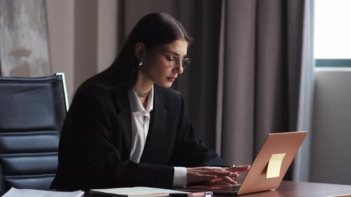 Professional Woman Working on Laptop in Modern Office