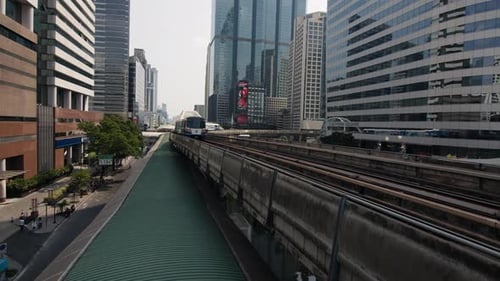 sky train moves through a modern cityscape in Bangkok