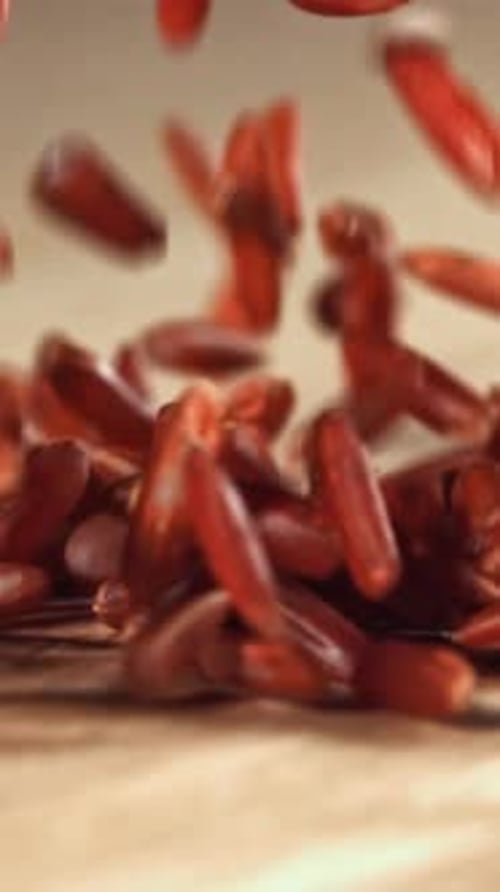Red Rice Falls on a Wooden Table Filmed on a Highspeed Camera at 1000 Fps