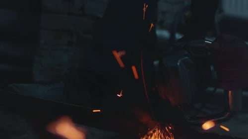 Metalwork sparks during industrial cutting process in workshop