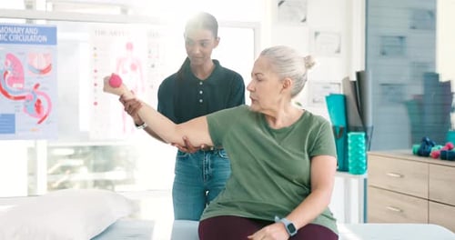 Physical Therapist Helping Senior Woman Lift Weights