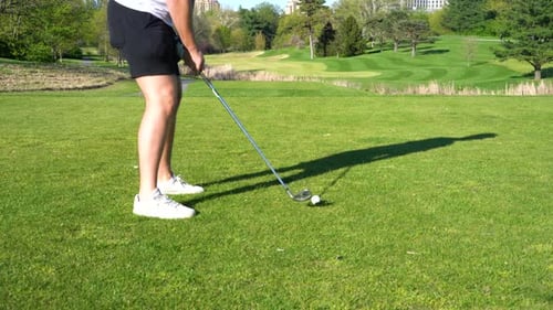 Man Practicing Golf Swing on Sunny Green Course