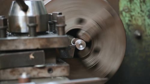 Close-up 4K scene operation of lathe machine cutting the brass shaft parts and the cutting chips. Th