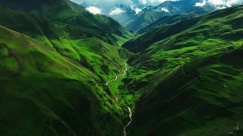 Serpentine River Meandering Through a Vibrant Green Mountainous Landscape with Dramatic Lighting