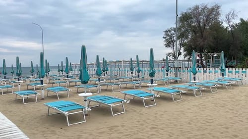 Sandy Beach with Parasols and Empty Deck Chairs Awaiting Tourists
