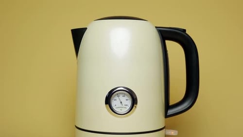Stylish Kettle with Temperature Gauge on Yellow Background