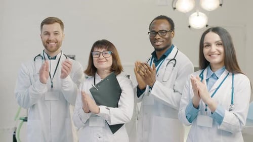 Group of doctors standing together and applaud in medical clinic