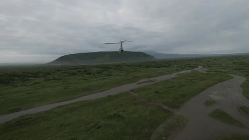Helicopter Flying Over Green Landscape on Overcast Day