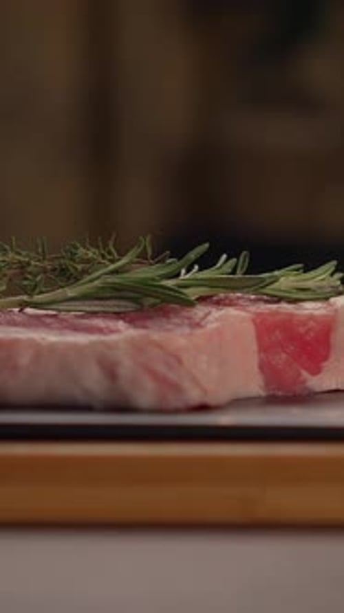 Freshly Prepared Meat Garnished with Aromatic Herbs Presented Beautifully on a Wooden Cutting Board