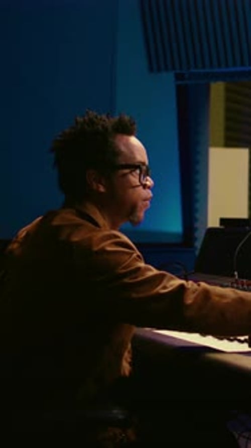 Musician Plays Keyboard in Dimly Lit Studio