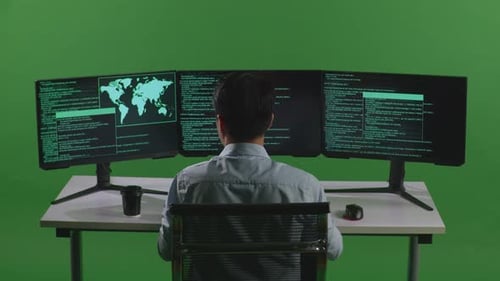 Back View Of Asian Man Developer Using Computer To Write Code With Multiple Screens In Green Screen