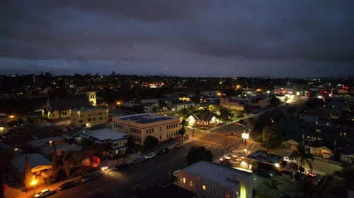 Aerial drone footage flying northeast above downtown San Diego revealing illuminated buildings,