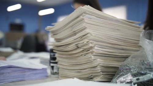 Stack of Paper on a Desk in Office
