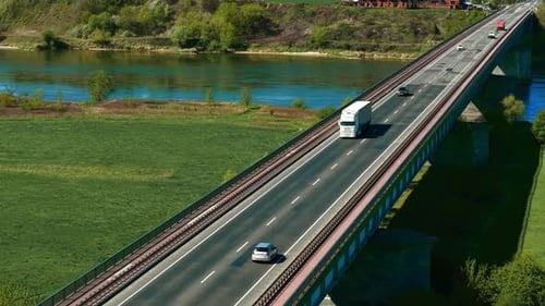 Semi Truck Driving on Busy Bridge Over River with Other Vehicles in Motion Freight Hauler Delivering