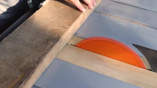 Woodworker Using Table Saw to Cut Lumber