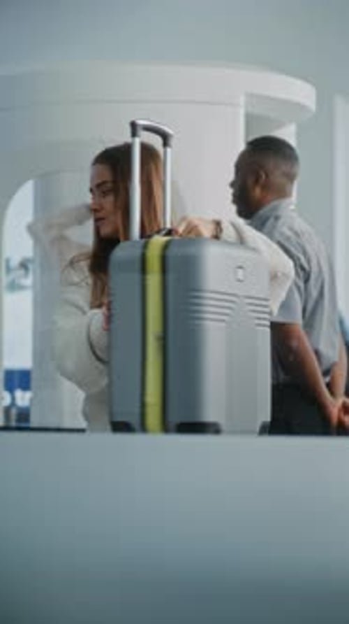 Woman Placing Suitcase on Airport Check-In Counter
