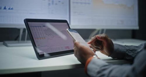 Hands using phone and tablet in modern office