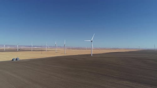 Wind turbine powers green energy on an Oregon farm field from an aerial view