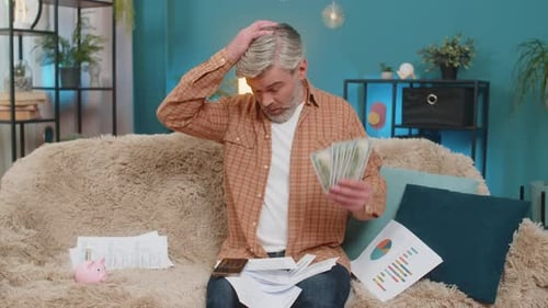Man Concerned Over Finances While Seated on Couch