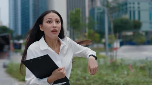 Businesswoman Is Late For Work Holding Documents In Her Hands Rushing on the Street