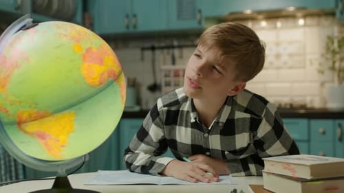 Boy with Globe Doing Homework at Table