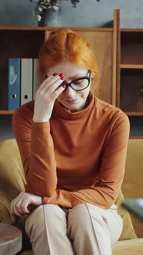Thoughtful Woman Sitting on Couch Indoors
