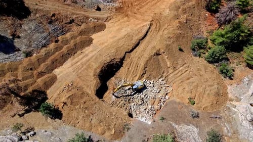 A work machine digging in the field from a drone camera
