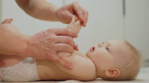Adult Interacting with Infant's Hands and Feet Indoors