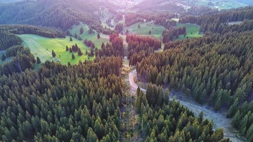 Lift with Cable Passes Between Spruce Forest on Peak Against Backdrop of Mountain Ranges of Rhodope