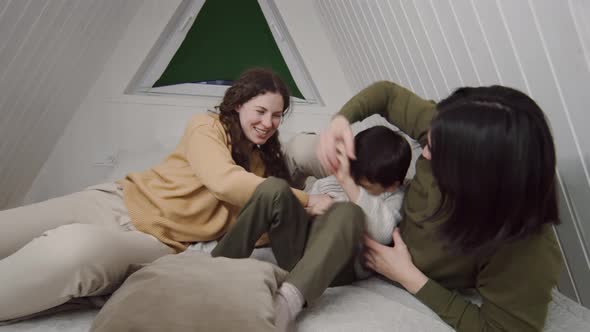 Young Family Having Fun Scuffle on Bed in Attic, Lifestyle Stock ...