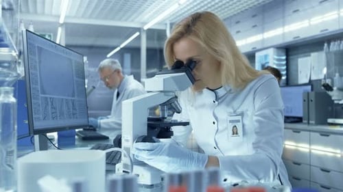 Scientist Using Microscope in Lab for Research