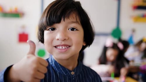 Happy asian child looking at camera, smile face with school classroom on background. Education
