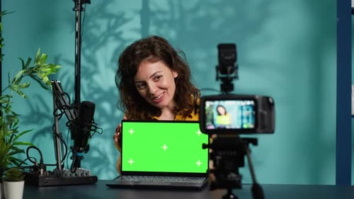 Woman Recording Video in Studio with Green Screen Laptop