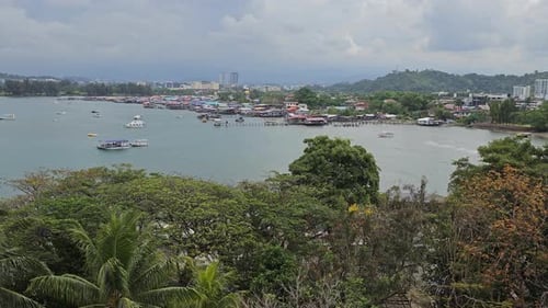 A praia de Tanjung Aru, vila de pescadores na água na orla marítima de Kota Kinabalu. Árvores tropicais exuberantes
em