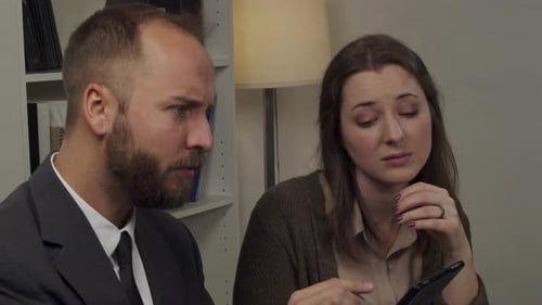 Colleagues Reviewing Tablet Together in Office Environment