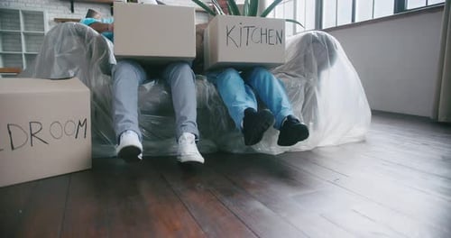 Couple Lying on Sofa Holds Boxes for Arrangement of New Flat