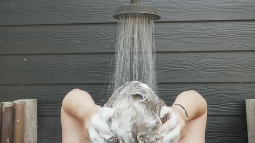 Woman Shampooing Hair Under Outdoor Shower