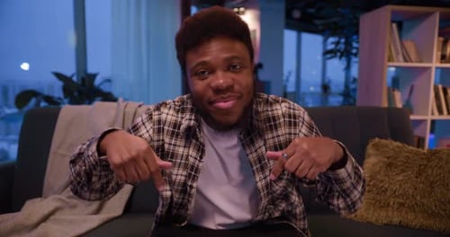 Young Adult Talking Directly to Camera on Sofa