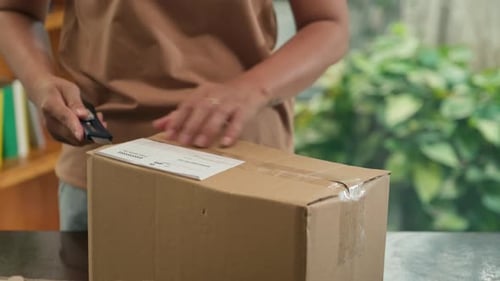 Hands Opening Cardboard Box With Box Cutter