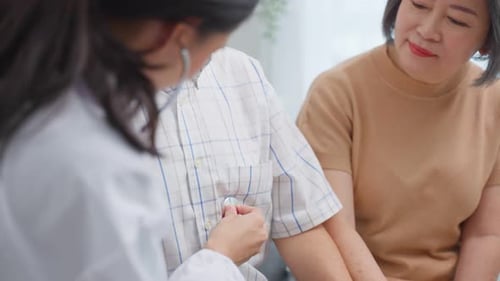 Doctor Listens to Elderly Patient's Heart at Home