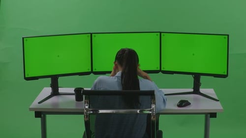 Asian Woman Having Headache While Working With Mock Up Multiple Computer Monitor In Green Screen